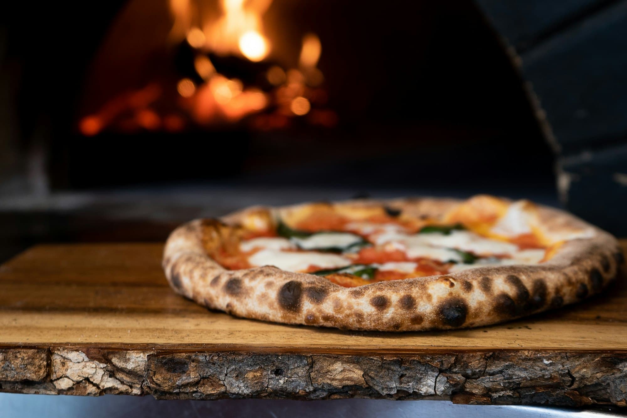 Pizza napolitaine devant un four à bois