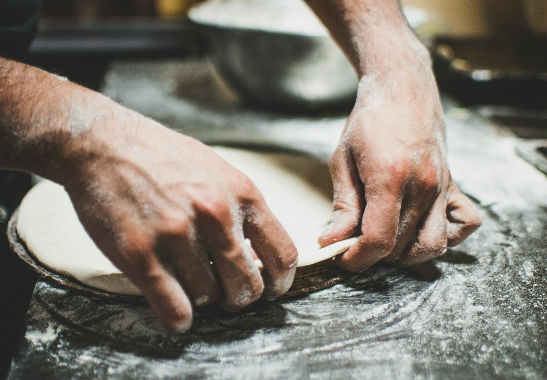 Pizzaïolo façonnant une pâte à pizza à la main